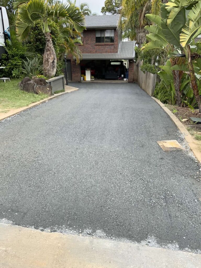 Freshly compacted road base on a residential driveway, showing correct preparation and material use before final sealing.